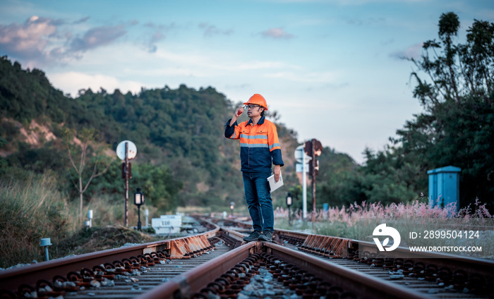 Engineer under inspection and checking construction process railway switch and checking work on railroad station .Engineer wearing safety uniform and safety helmet in work.