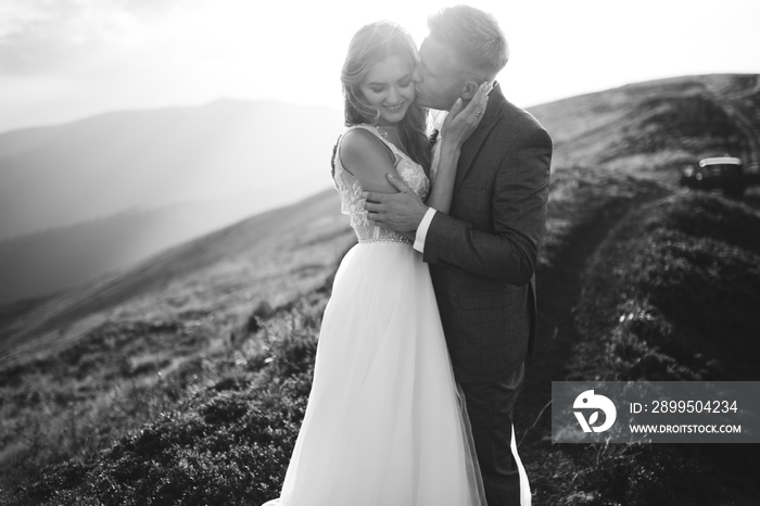 Beautiful wedding couple, bride and groom, in love on the background of mountains