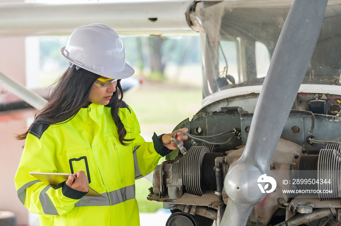 Technician fixing the engine of the airplane,Female aerospace engineering checking aircraft engines,Asian mechanic maintenance inspects plane engine