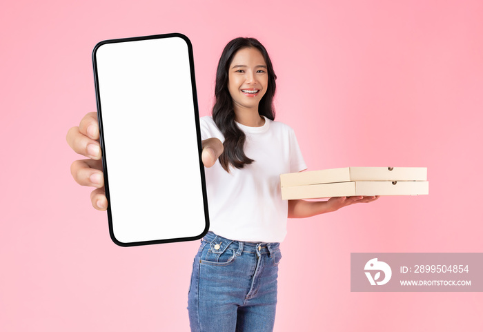 Studio shot of Beautiful Asian woman holding pizza boxes and smartphone mockup of blank screen isolated on pink background.