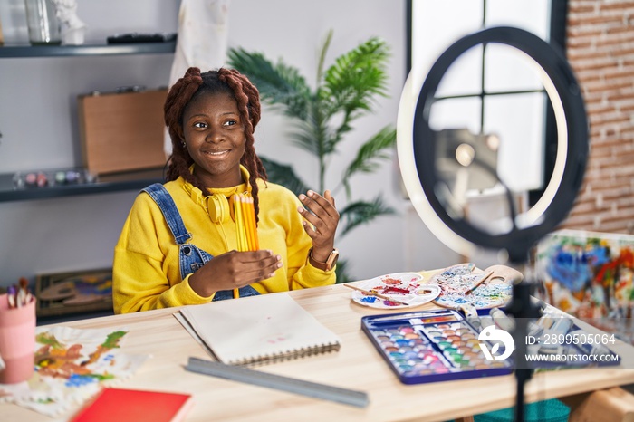 African american woman artist recording video showing pencils at art studio