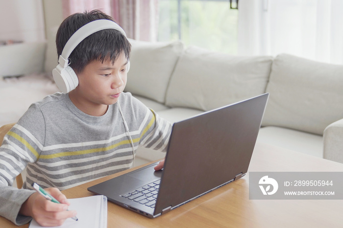 Preteen tween teen boy making facetime video calling with laptop at home, using zoom online class meeting app, social distancing,homeschooling,learning remotely , new normal concept