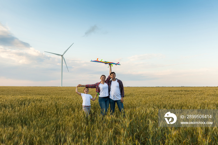 Happy family having fun with kite on the field.