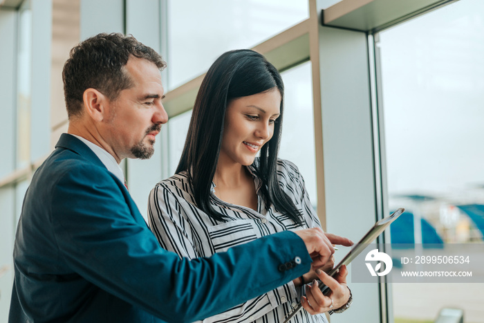 Man and woman talking about contract in car dealership.