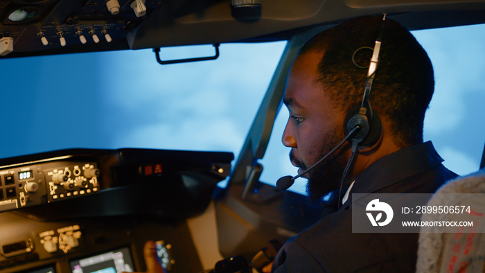 African american copilot using airplane command to fly plane, throttling power engine to takeoff. Control panel navigation with radar compass and dashboard in captain cabin. Close up.