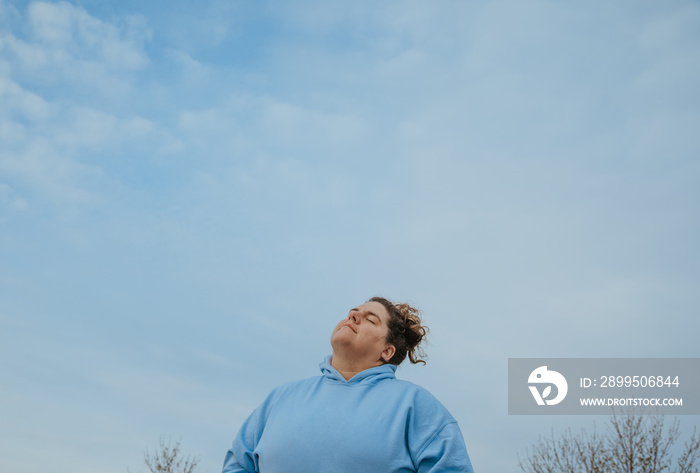 plus size woman lifts chin towards sky