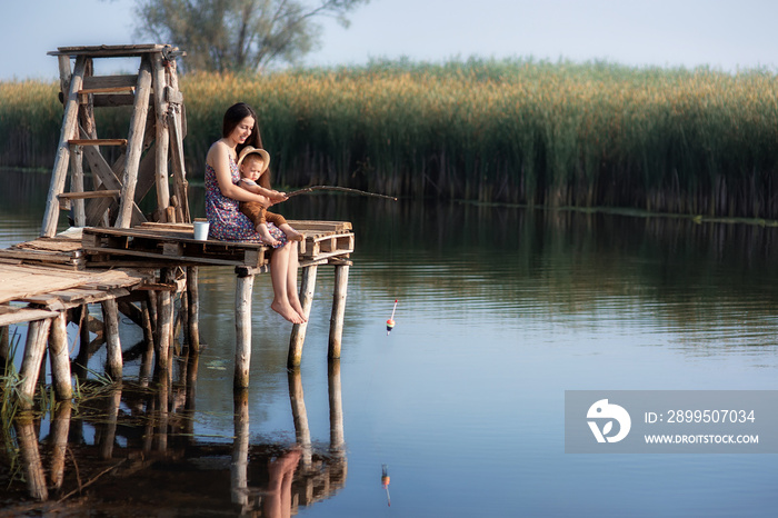 little boy with mother fishing on the lake