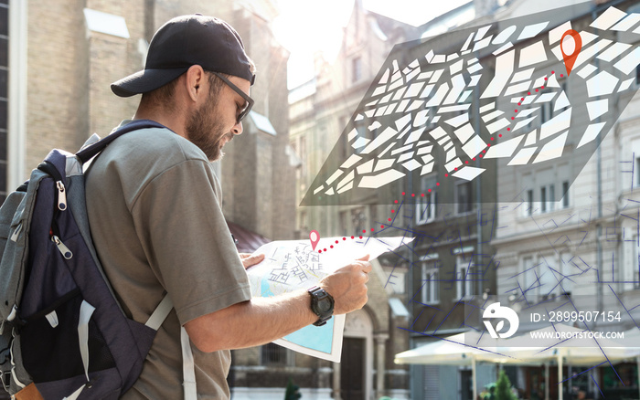 Man with backpack traveling around city holding map in hands, searching route, digital map visualisation in the space.