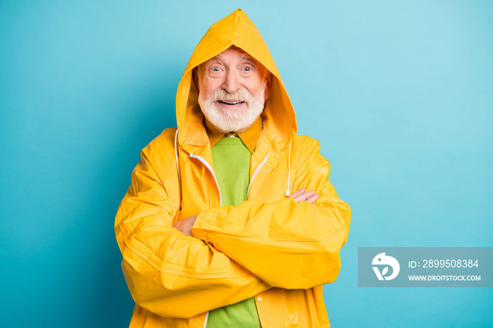 Close-up portrait of his he nice cheerful cheery grey-haired man tourist wearing yellow overcoat folded arms good weather forecast isolated on bright vivid shine vibrant blue color background