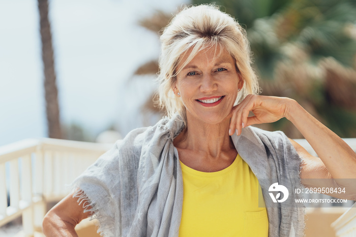 Stylish blond woman sitting on a balcony