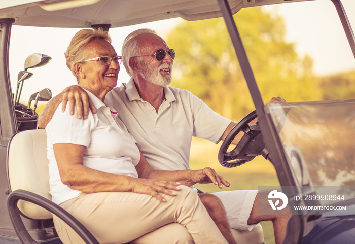 Golfers couple are riding in a golf cart and talking.