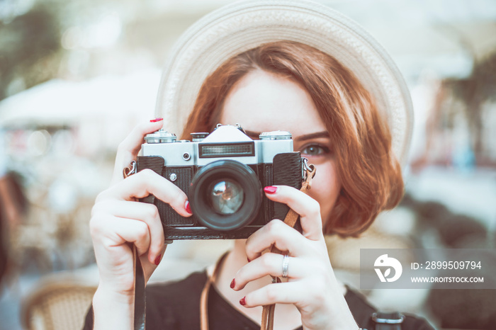 Closeup portrait of a young hipster woman with retro camera outdoors