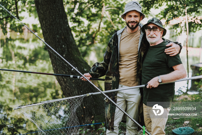 Positive delighted embracing his father while fishing