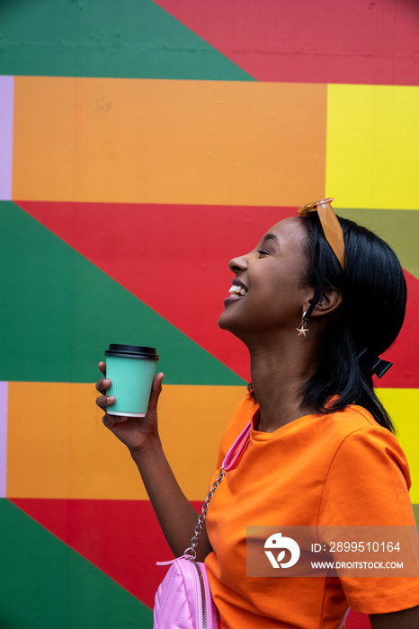 Young woman drinking take-out coffee outdoors