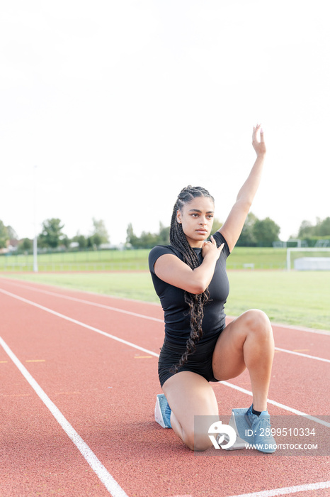 Female athlete stretching before run at stadium