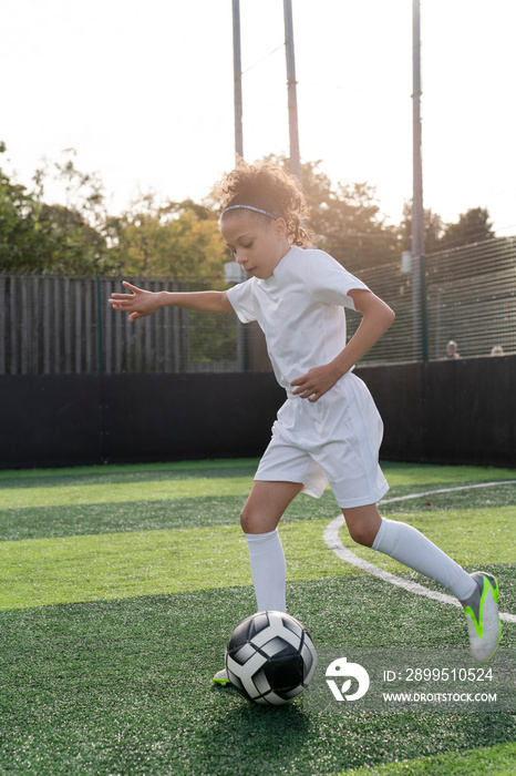 Girl (6-7) playing soccer on soccer field