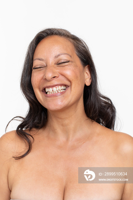 Studio portrait of smiling shirtless woman laughing