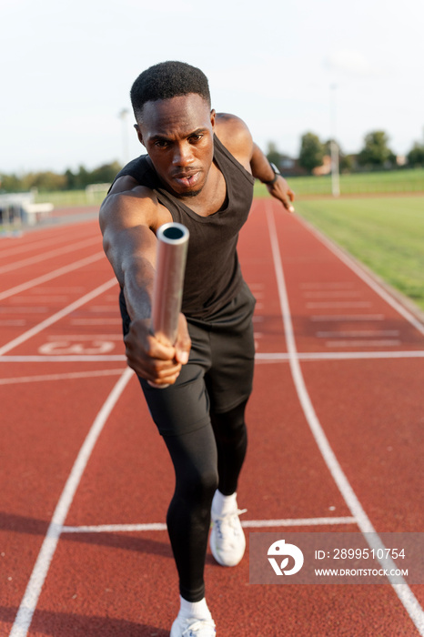 Athlete holding relay baton during race