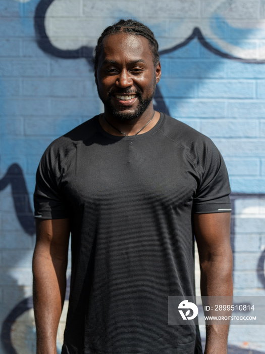 Portrait of smiling muscular man in sports clothing