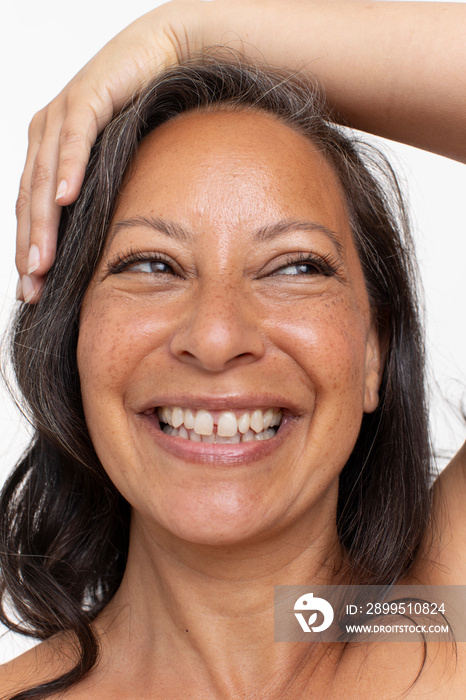 Close-up of smiling woman with hand on head