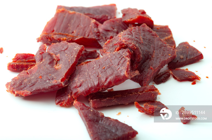 High protein diet and food that is high in sodium and salt concept theme with close up on beef jerky meat strips isolated on white background