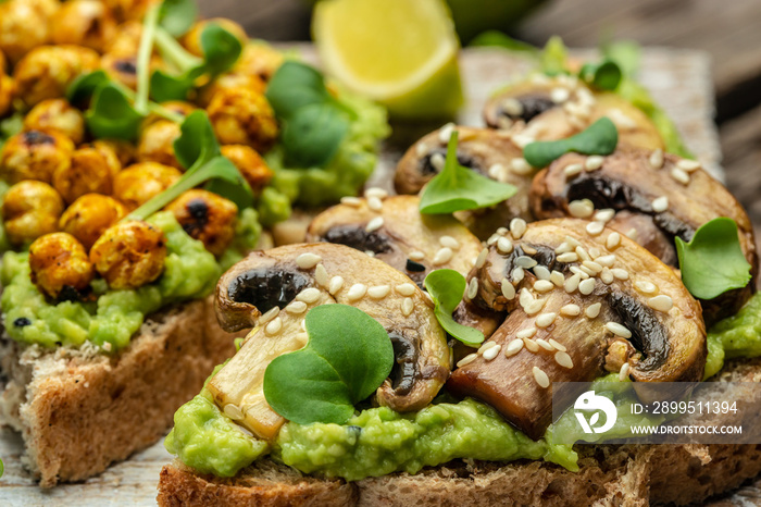 toast with avocado, roasted chickpeas and mushrooms on a dark background. superfood concept. Healthy, clean eating. Vegan or gluten free diet