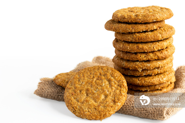 Homemade shortbread cookies made of oatmeal are stacked on sackcloth on the  white table background. Concept food healthy snack for enjoy in holiday. With copy space for text.