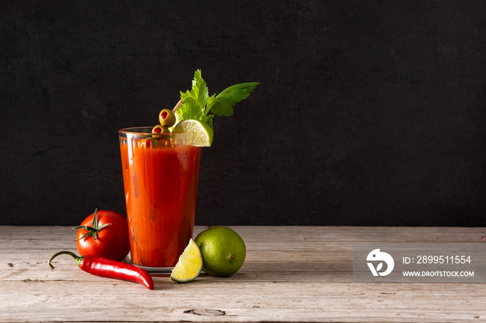 Bloody Mary cocktail in glass on rustic wooden table. Copy space