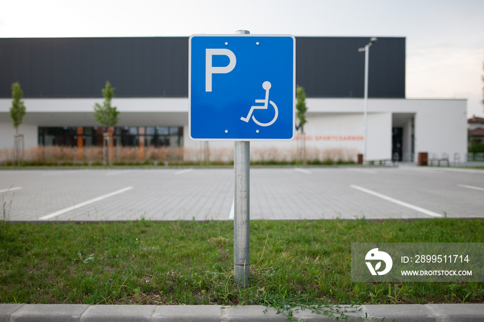 Disabled traffic sign at an empty car park represent handicap parking space without car or people