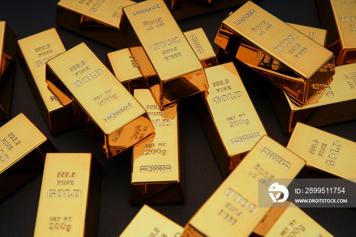 Scattered gold bars on the black table. Shiny precious metals for investments or reserves. Bank image and photo.