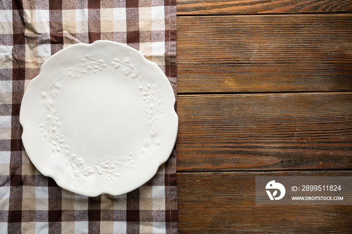 Overhead view of empty white plate on wooden table