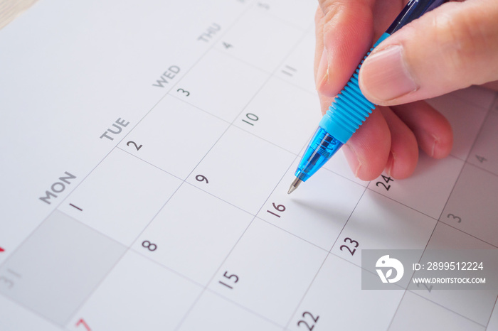 Woman hand with pen writing on calendar date business planning appointment meeting concept