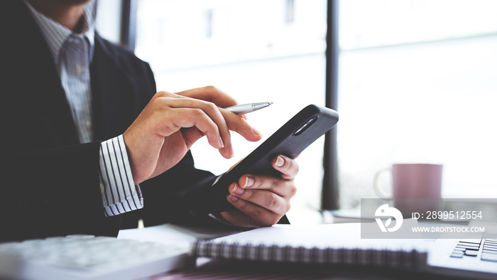 Businesswoman or accountant using the phone to check business information. Accounting Documents and Laptop at Small Office Business Ideas