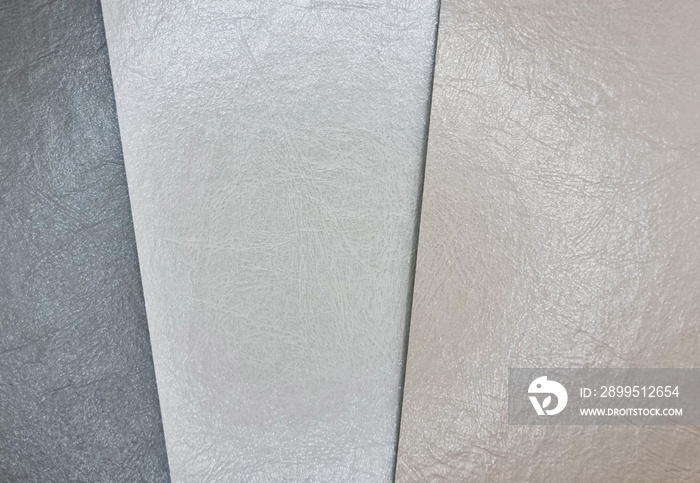 various color in grey, beige and brown tone of lether laminated samples. close up view of grunge leather samples swatch. interior furnishing material for selection (focused at center of image).