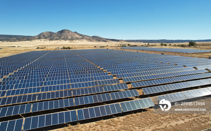 Aerial drone shot of a large solar array power plant in the desert generating clean electricity from the sun.