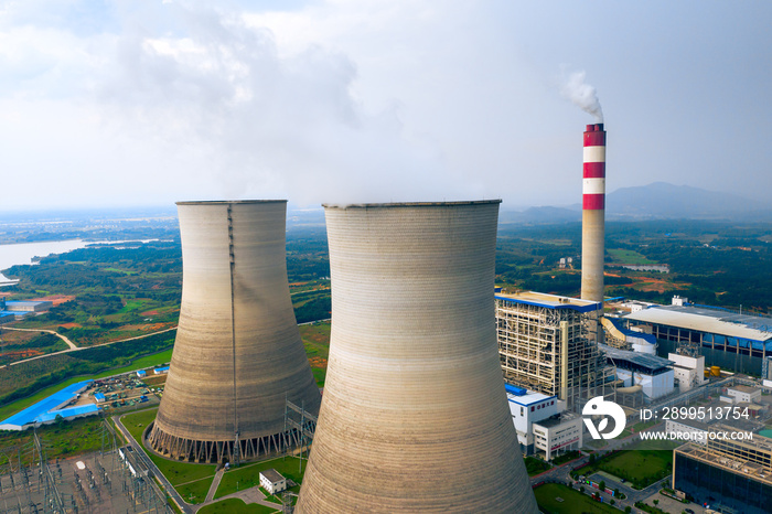 coal fired power station with cooling towers releasing steam into atmosphere