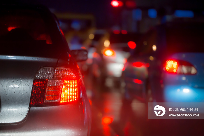 car brake light in raining night busy road, driving in rain for background.