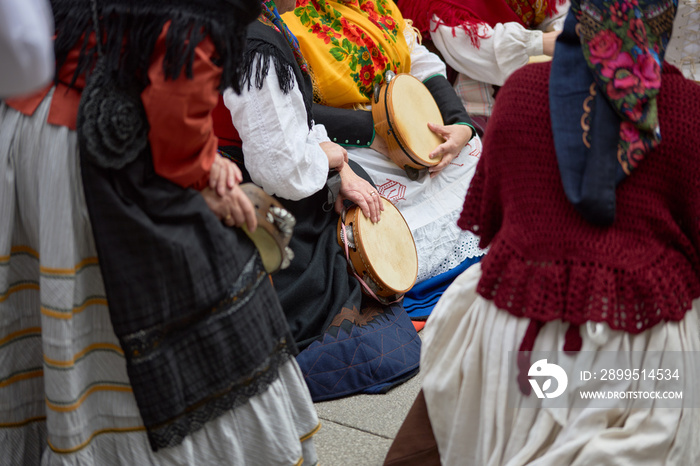 Women in period costumes playing tambourines at a popular festival in the city of Vigo, Galicia, Spain.