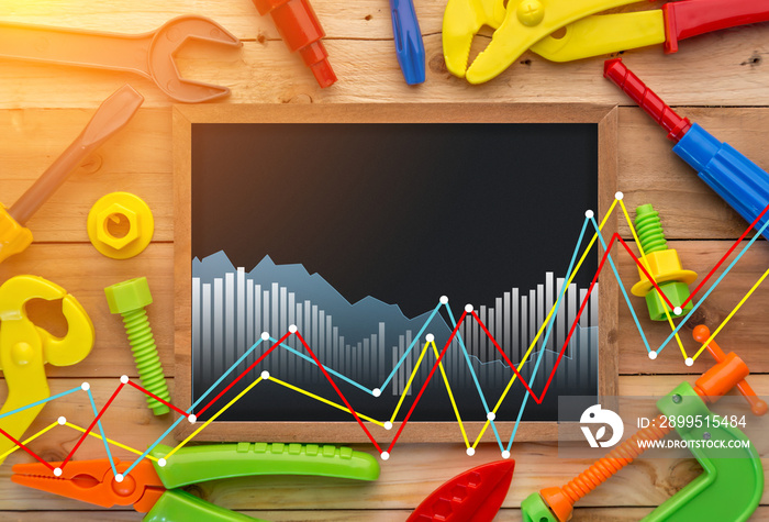 Working tools toys and analysis chart chalkboard on a wooden floor background. with business graph chart double exposure image