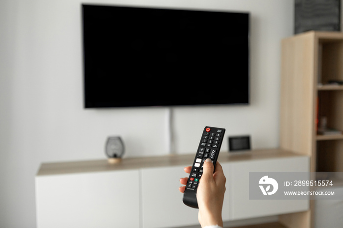 A man watches TV and uses the remote control.