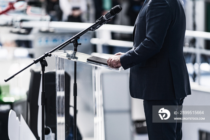 Male Speaker Standing In Front Of Microphones