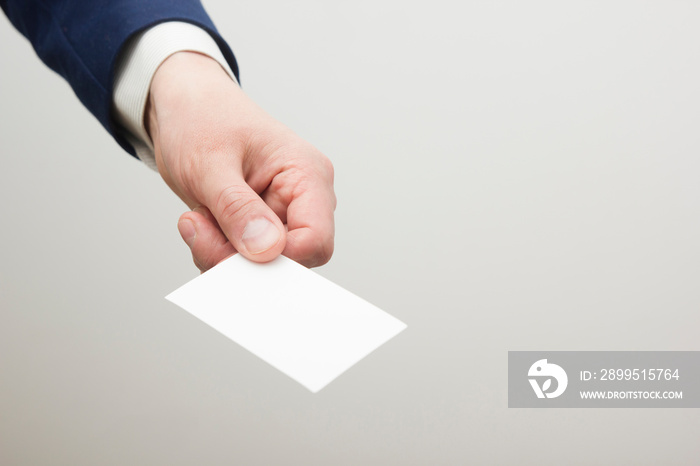 Hand holding white business card on white background