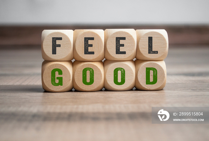 Cubes and dice with message feel good on wooden background