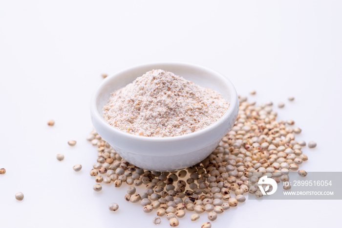 Uncooked raw Sorghum flour (also known as sorgo) in a white bowl, isolated on white background