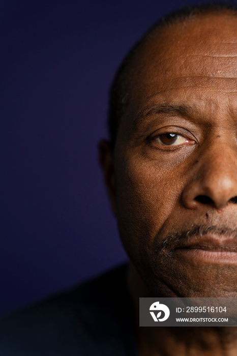 Portrait of serious man against purple background