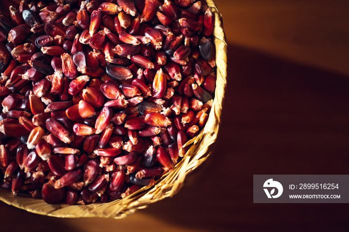 Red mexican corn on wicker basket. Top view of red corn. Concept of corn food