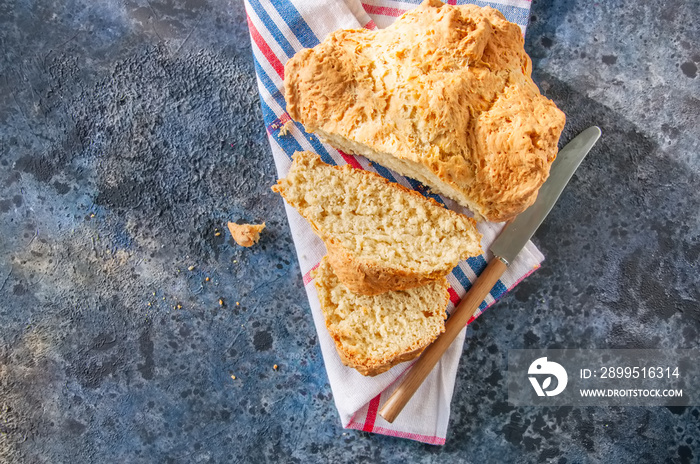 Traditional Irish soda bread on a towel on a blue stone background.