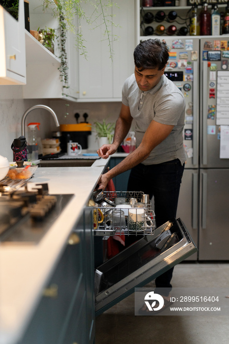 Man putting dishes into dishwasher