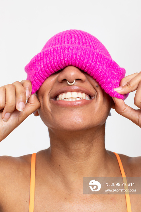 Studio portrait of smiling woman in pink woolen cap