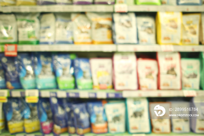 Blurred view of packs with animal food on pet shop shelves